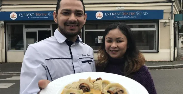 Prem Bam et son épouse devant Everest Bistro Blend, présentant une assiette de momos